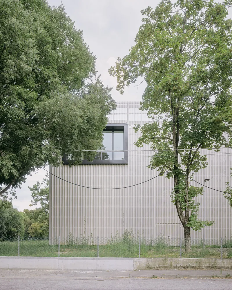 A large glazed "eye" in the façade marks a flexible workshop space. Photo © Aldo Amoretti
