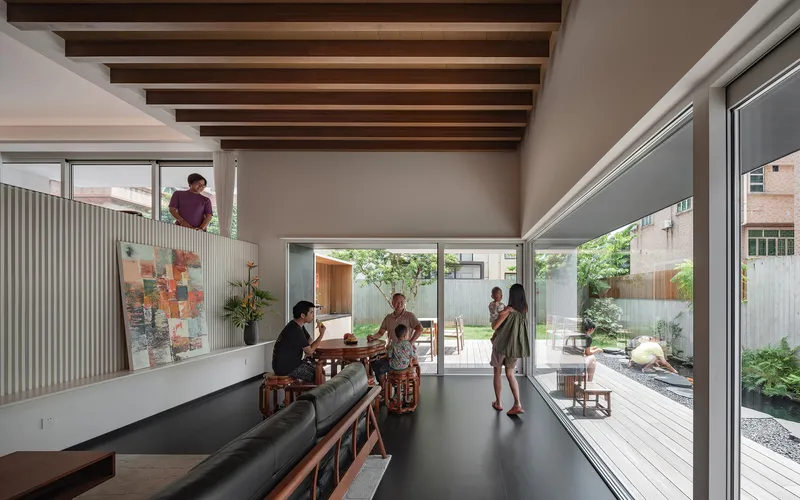 Open living space with exposed timber beams, mezzanine, and views to rear courtyard garden