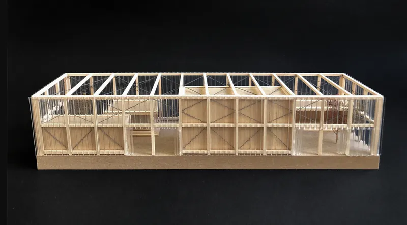 The scale model reveals Kaffeebühnen’s linear shell, layered timber boxes, and blurred indoor outdoor structure.