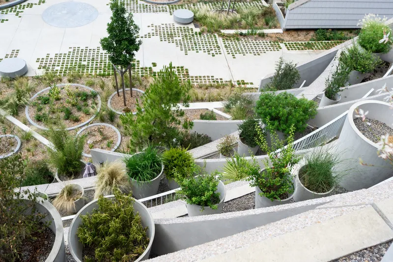 Aerial view of the curving white planter beds and permeable paving grid at ground level