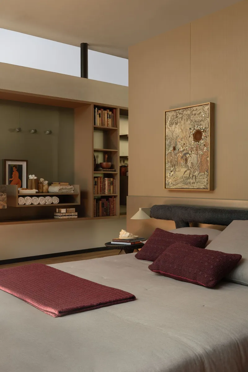 Bedroom with built-in shelving and clerestory window above in warm afternoon light