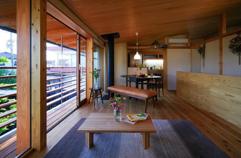 Open living and dining space with exposed timber ceiling and horizontal slatted shutters