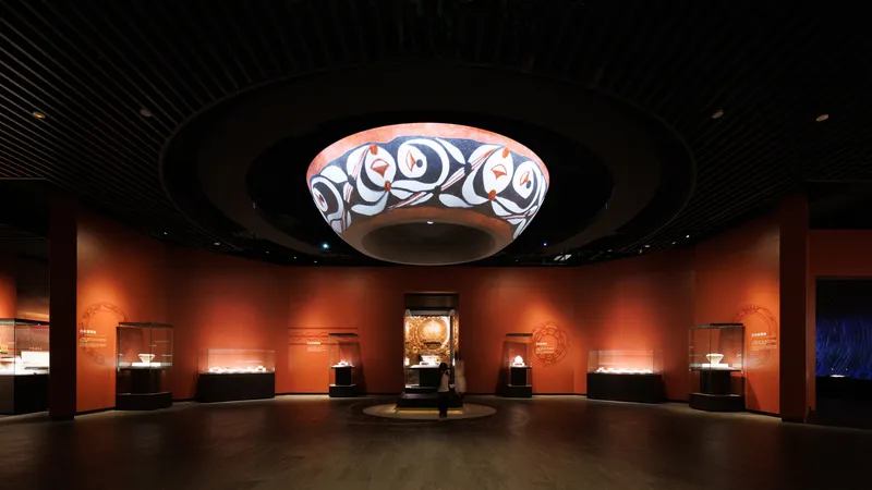 Gallery space with circular soffit displaying patterned textile beneath a dark slatted ceiling