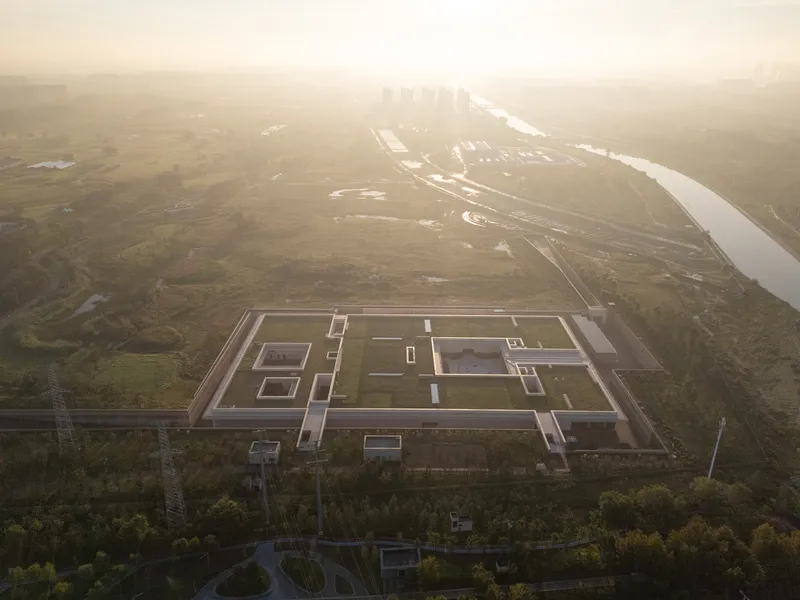 Drone view of the rectilinear roof composition surrounded by wetlands in morning haze