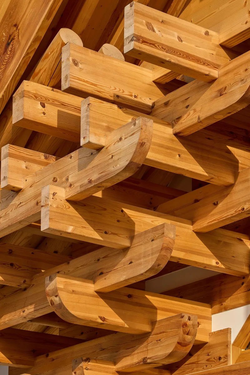 Close-up of interlocking timber bracket system with curved arms radiating from a central point