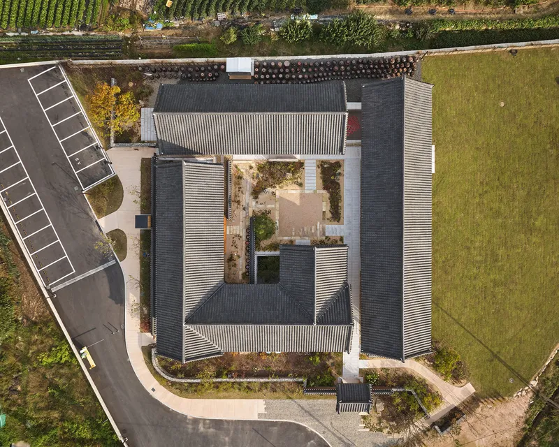Aerial view of the courtyard complex with tile roofs arranged around a central planted garden