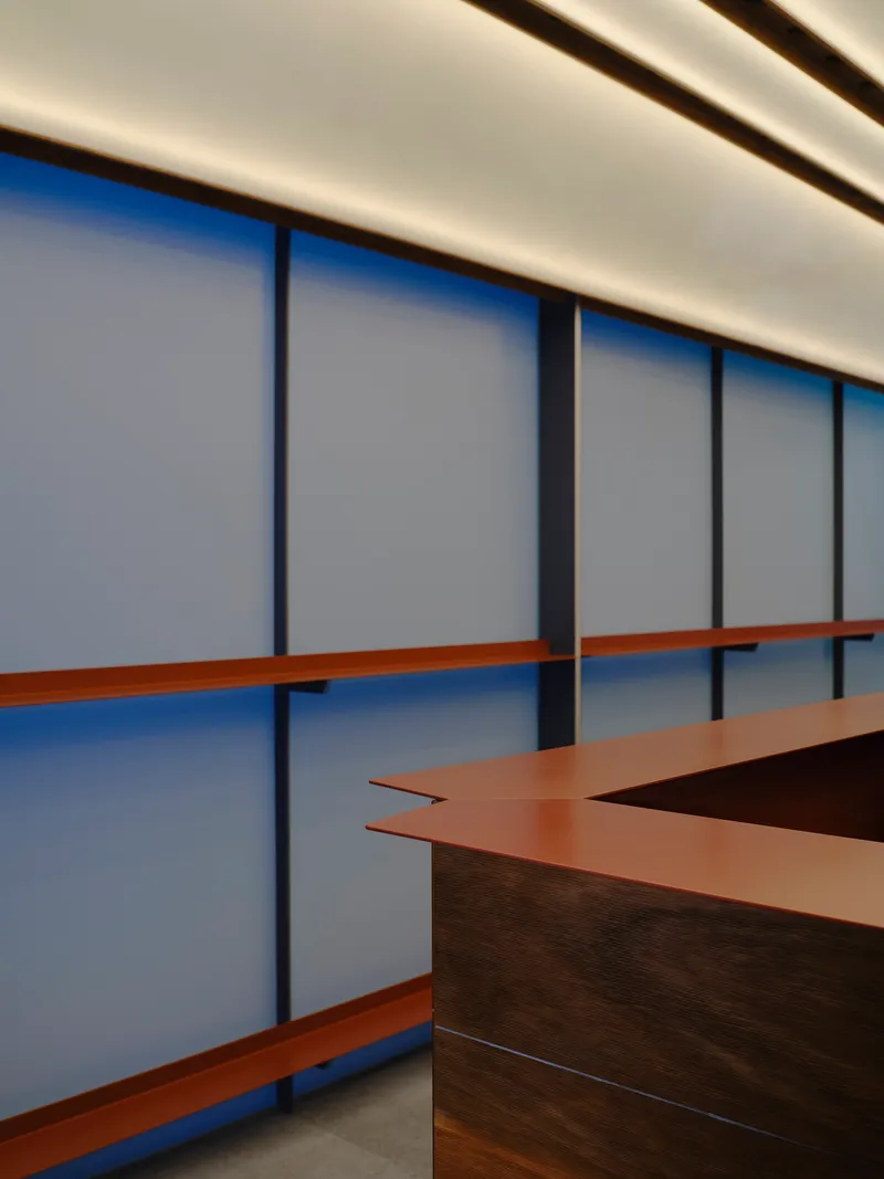 Angular copper countertop detail against the panel wall with backlit ceiling above