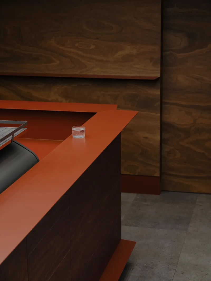 Orange terracotta worktop meeting dark timber wall panels with a glass of water