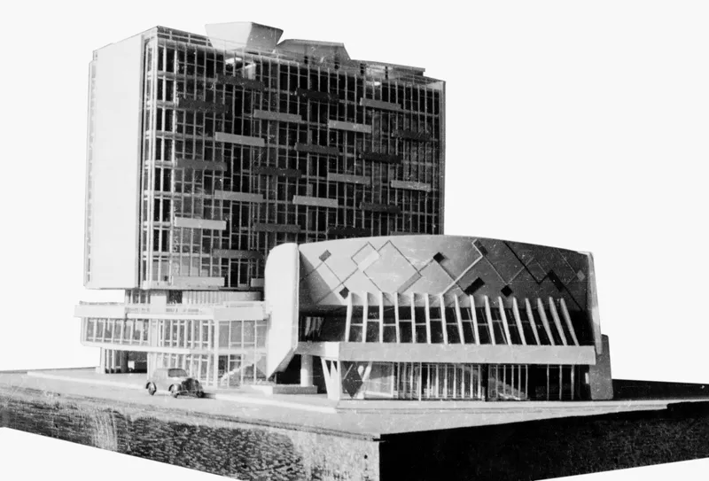 Physical model showing a tower with glass facade and a curved cinema volume with diamond roof