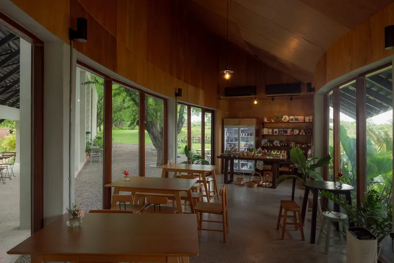 Interior dining space with timber ceiling and glass doors opening to veranda and lawn beyond
