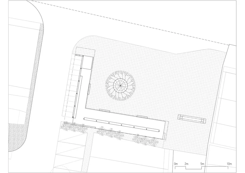 Site plan drawing showing a rectangular building with a central circular courtyard element and adjacent landscaped areas