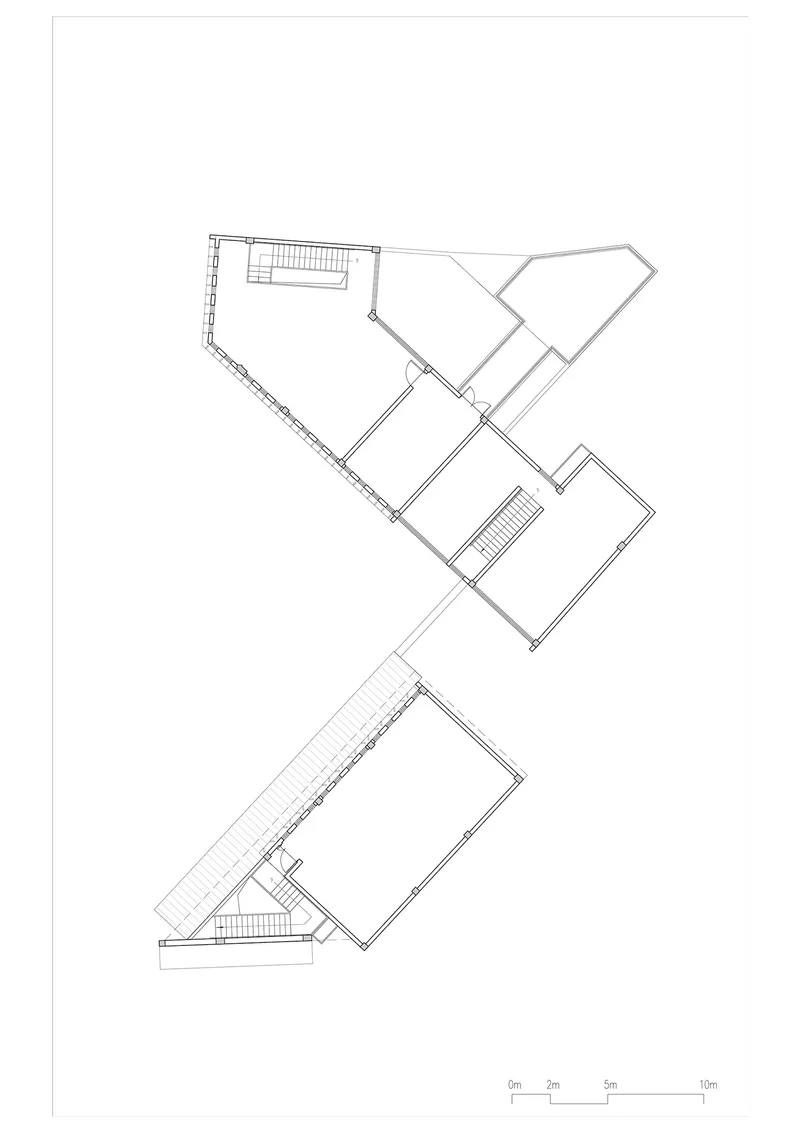 Upper floor plan drawing showing a fragmented building with angled wings and two staircases