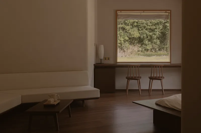 Interior workspace with two wooden chairs at a built-in desk overlooking a rocky hillside
