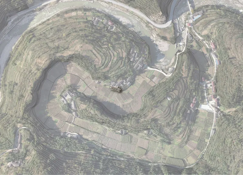 Overhead view of contoured farmland and scattered buildings following the topography of a hillside