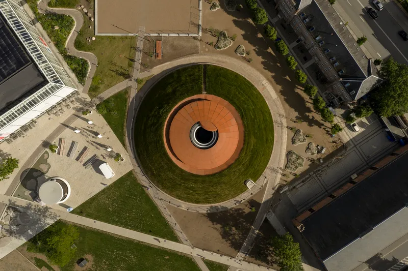 Aerial view of the circular sunken courtyard with concentric grass terraces and orange tile center