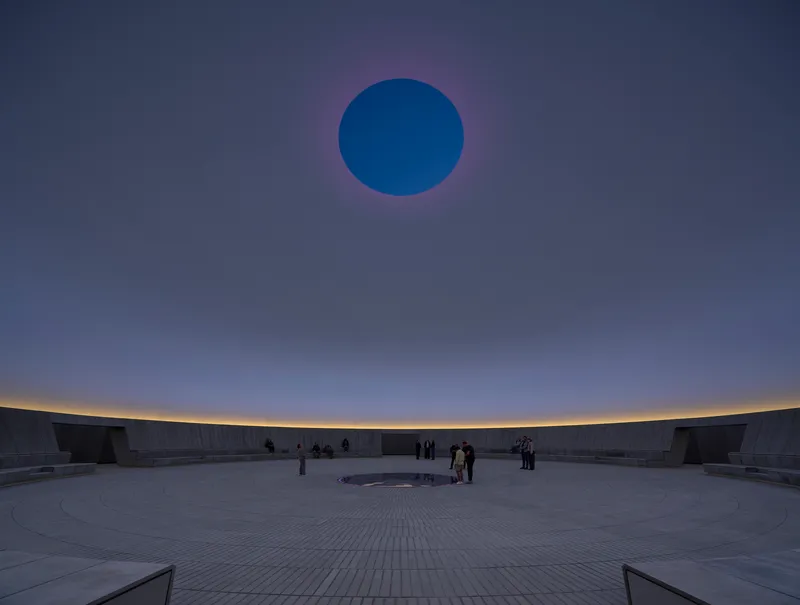 Interior view of the circular courtyard with central oculus and visitors gathering at dusk