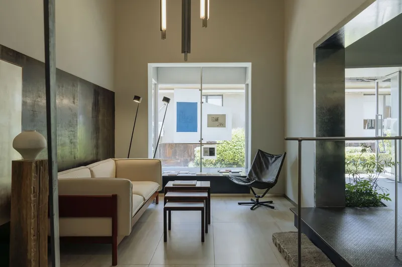 Living area with seating looking through to a courtyard garden with steel-clad partition