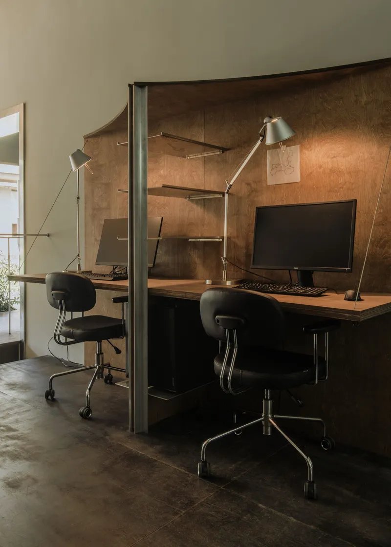Desk alcove with copper-finished wall panels and floating shelves in warm afternoon light