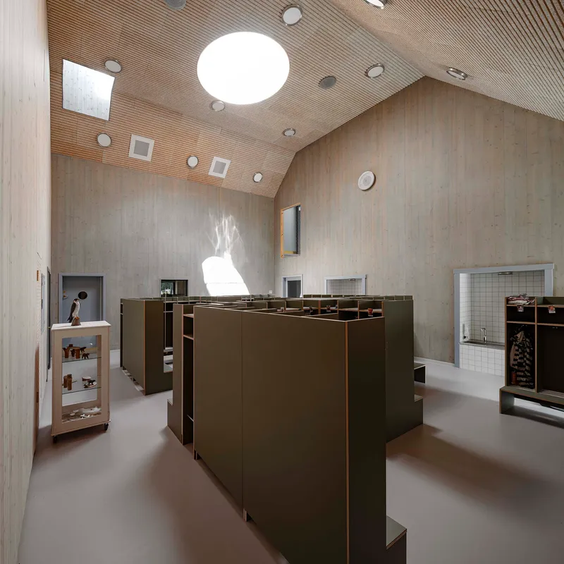 Retail interior with bronze display units beneath a ribbed timber ceiling with circular skylights