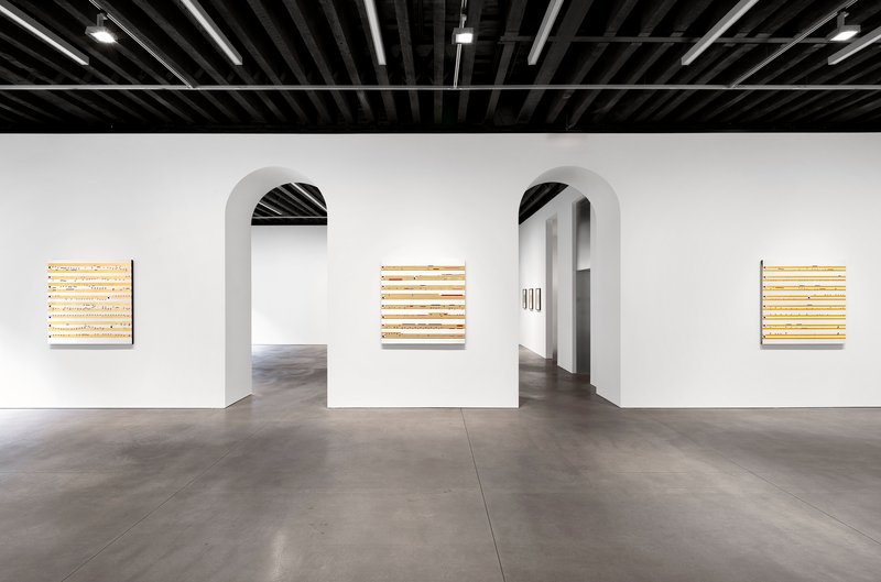 White partition wall with two arched openings beneath black painted joist ceiling