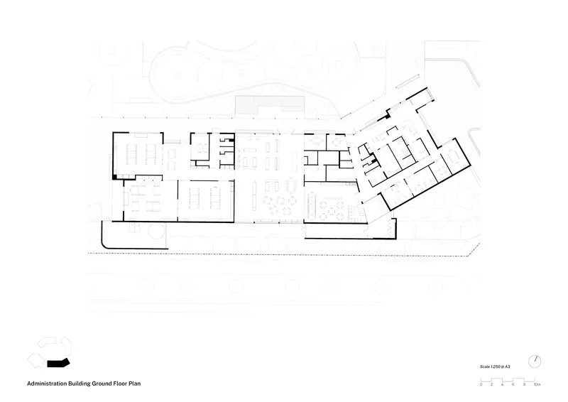 Ground floor plan drawing showing angled wings with classrooms branching from central shared spaces and administration areas