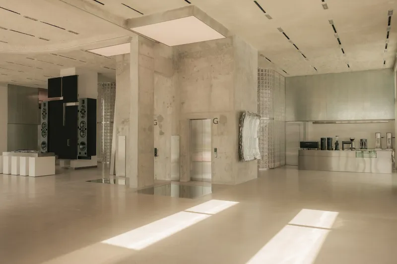 Interior with concrete walls and polished floor catching rectangular pools of natural light