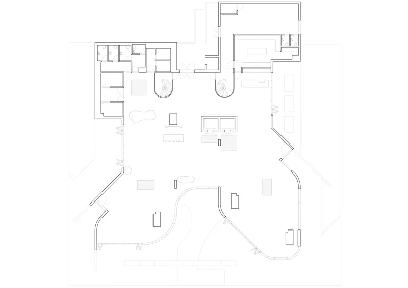 Floor plan drawing showing an open layout with curved perimeter walls and clustered service zones