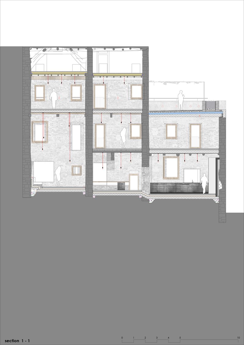 Building section drawing showing multilevel interior spaces within restored stone walls and new timber framing
