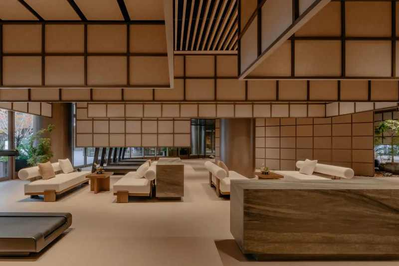 Reception area with timber desk and platform seating under a ceiling of gridded translucent panels