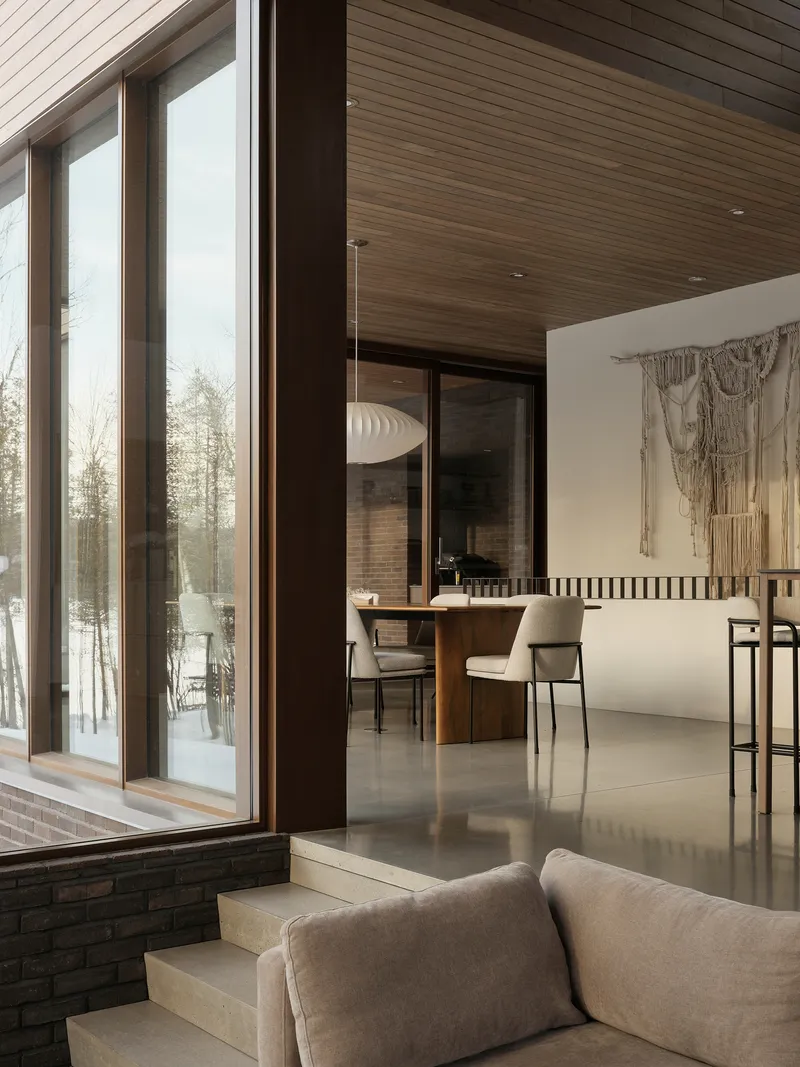 Split-level interior with dining area beyond glazed doors and timber soffit extending from exterior to interior