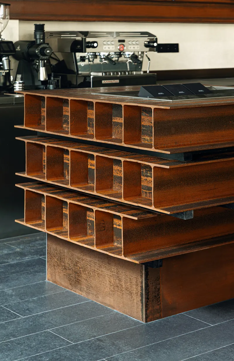 Close-up of stacked timber counter modules with open compartments beneath espresso machines