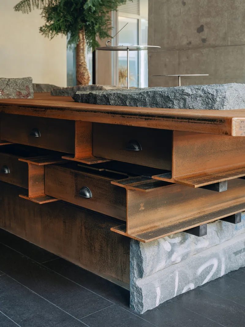 Reception desk with layered timber beams and rough stone base with carved detailing