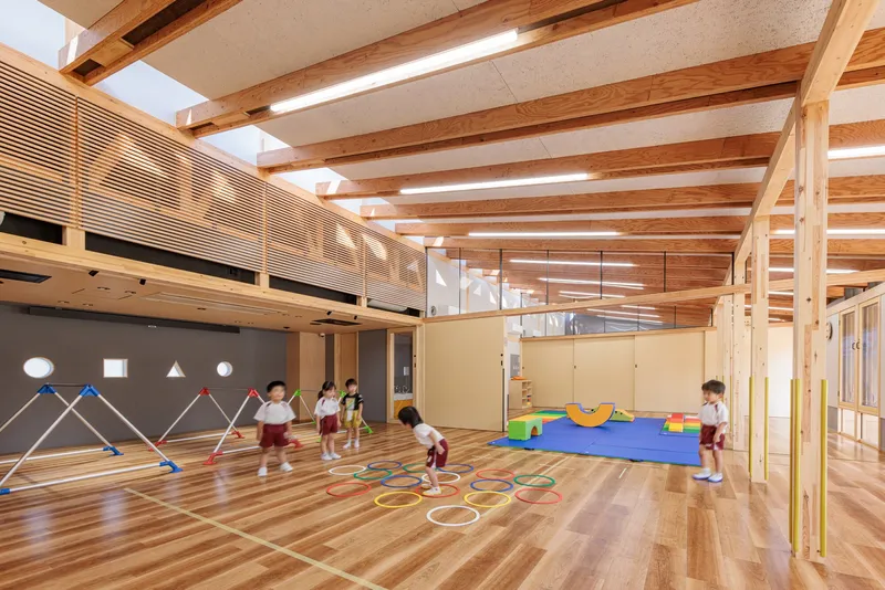 Play space with horizontal timber slat screen and mezzanine level where children use hoops and mats