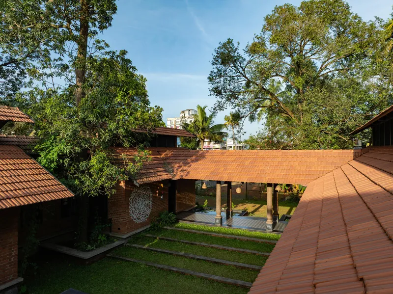 Courtyard view of a covered pavilion with timber columns under a terracotta tile roof