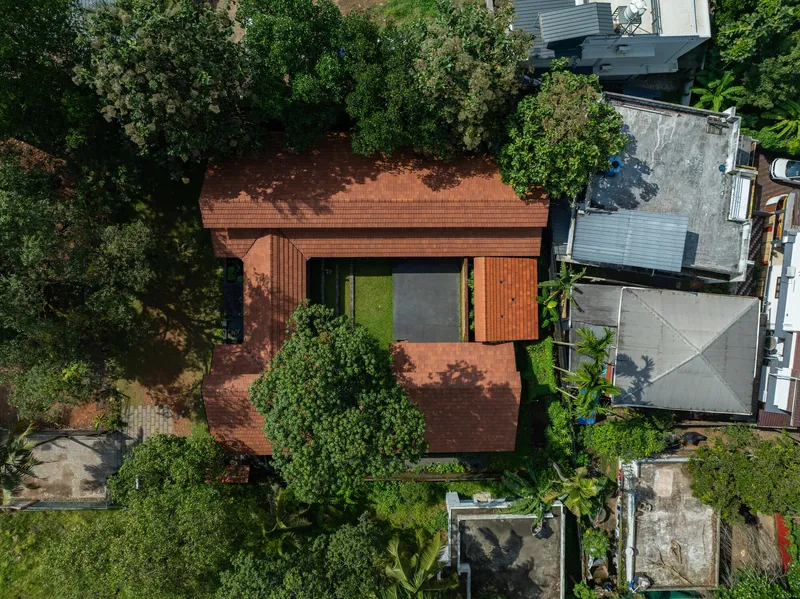 Aerial view of the terracotta tile roof surrounded by dense tree canopy and neighboring structures