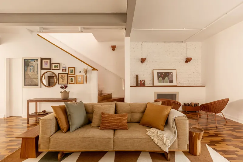 Living room with geometric patterned floor and staircase ascending behind a gallery wall