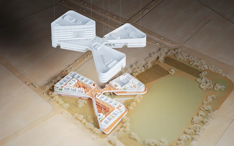 Aerial view of the physical model showing the triangular building forms beside a pond with trees