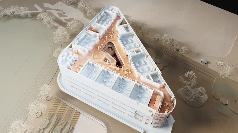 Aerial view of a physical model showing a triangular building with a central courtyard and surrounding landscape
