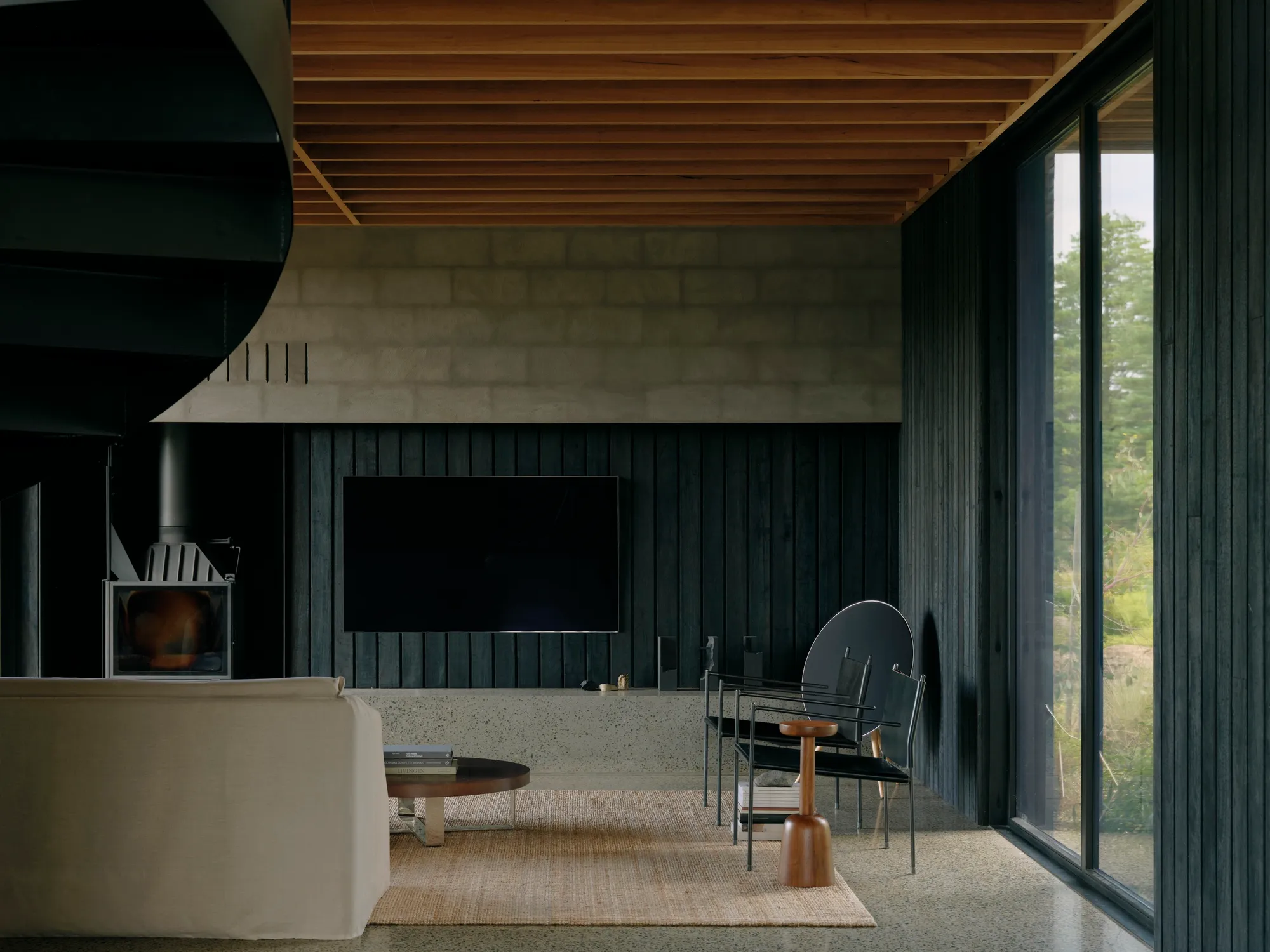 Tristan Burfield Turns a Red Hill Hillside Into a Fortress of Charred Timber and Rendered Masonry