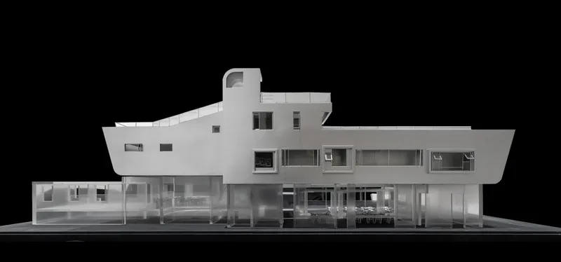 Physical model elevation showing a white two-story facade with horizontal ribbon windows and transparent ground floor