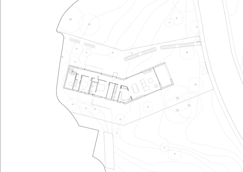 Site plan drawing showing an angled building volume with interior divisions and surrounding landscape contours