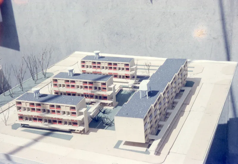 Physical model showing three stepped residential blocks and a linear slab building arranged around a central courtyard