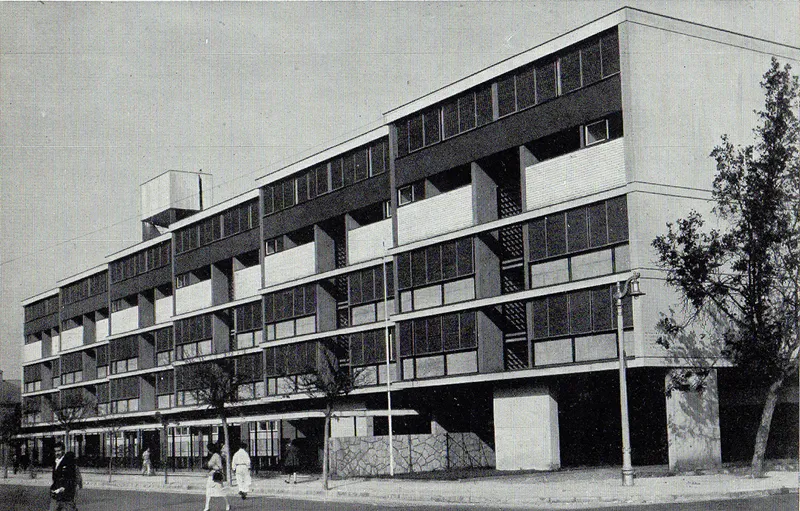 Elevation of the residential block with checkerboard facade pattern and pilotis at ground level beside young trees