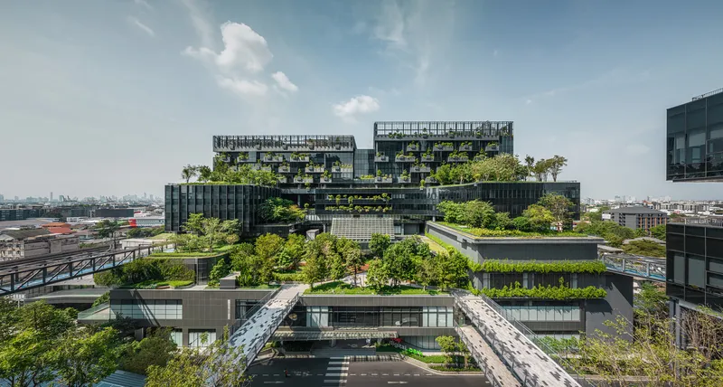 Elevated view of terraced rooftop gardens with trees cascading across multiple levels under a clear sky