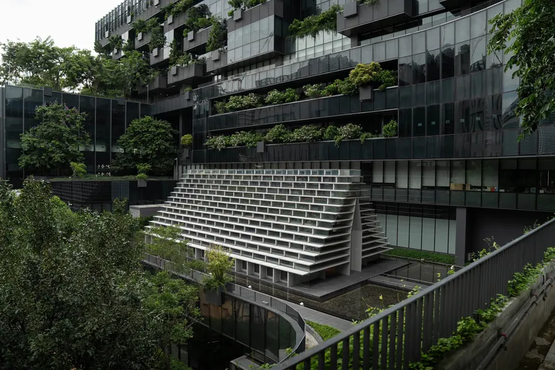 Side view of the cantilevered white stepped structure bridging between planted terraces on a rainy day