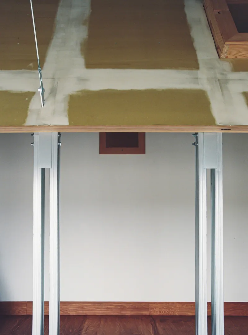 Sliding door hardware and ceiling junction showing the exposed formwork pattern on the overhead concrete surface