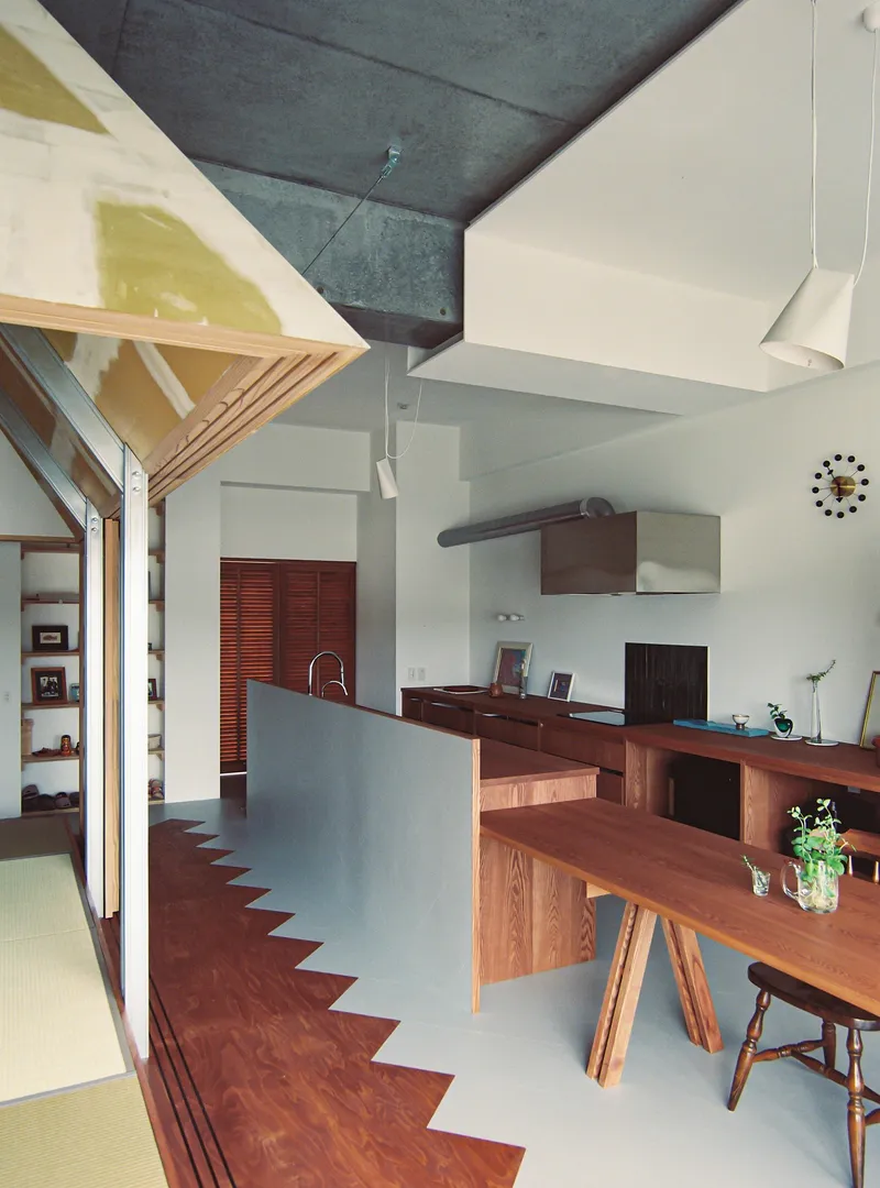 Kitchen and dining area with zigzag floor pattern and plywood truss structure overhead
