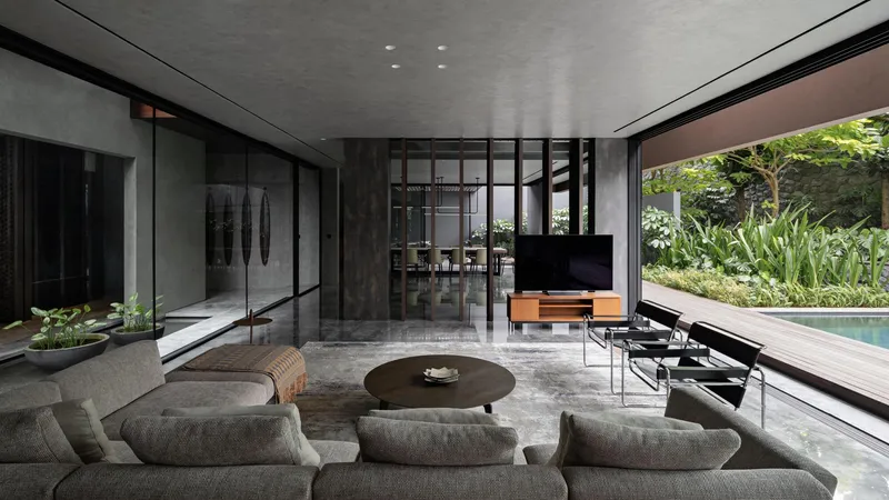 Open living area with polished concrete floor and glazed wall opening to poolside garden