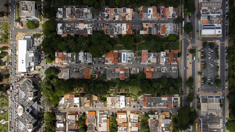 Overhead drone photograph of residential neighborhood showing varied rooftops, street grid, and tree-lined blocks