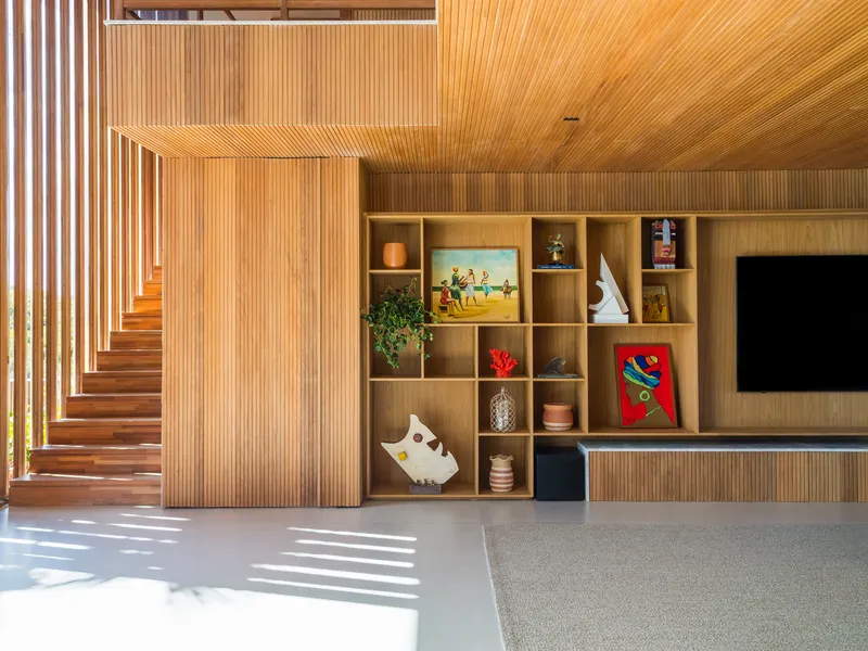 Interior view of timber staircase and display shelving with morning sunlight striping the floor
